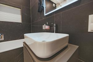 a bathroom with a white sink and a mirror at Apartament Szlachecka in Warsaw