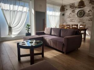 salon z kanapą i stołem w obiekcie La Sweet du Globe Maubeuge w mieście Maubeuge