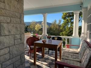 a patio with a table and chairs on a porch at Villa Bianca B & B in Cape Town