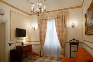 un soggiorno con finestra e lampadario pendente di Hotel Trinacria a Palermo