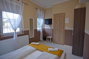 ein Schlafzimmer mit einem großen Bett und einem Fenster in der Unterkunft R.Gold Apartman in Makó