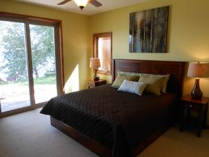a bedroom with a bed and a large window at Quarterdeck Resort in Nisswa