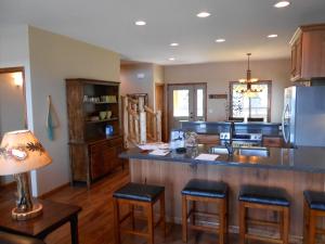 a kitchen with a bar with stools and a sink at Quarterdeck Resort in Nisswa