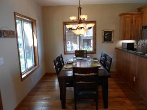 a dining room with a wooden table and chairs at Quarterdeck Resort in Nisswa