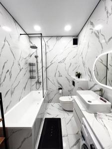 Un baño con lavabo, bañera e inodoro. en ЖК на Исы Байзакова, en Pavlodar 2 fotos más