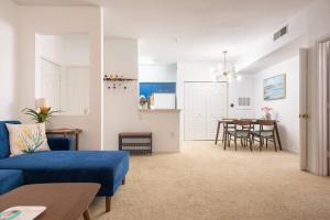 a living room with a blue couch and a table at o STUNNING CONDO MINUTES FROM GORGEOUS BEACHES o in Clearwater