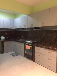 a kitchen with white cabinets and a black counter top at Brown Gate House in Panabo