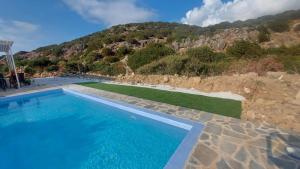 a swimming pool with a mountain in the background at Villa Edna Crete in Agios Nikolaos