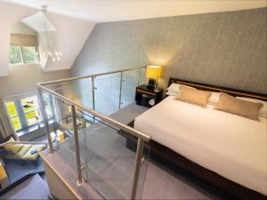 a bedroom with a bed and a glass staircase at BrookLodge & Macreddin Village in Aughrim