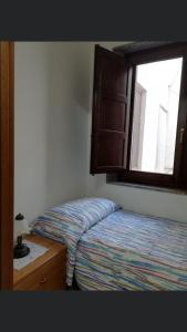 a small bedroom with a bed and a window at Casa Vacanze Da Laura in San Vito lo Capo