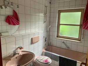 a bathroom with a sink and a toilet and a tub at Einladendes Appartement im Grünen für 2 Personen in Ostrach