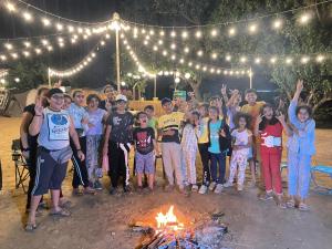 a group of people standing around a fire at Bombay Camping Company in Lonavala