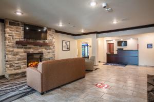 ein Wohnzimmer mit einem Sofa und einem Kamin in der Unterkunft Cobblestone Inn & Suites - Pine Bluffs 