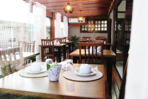 a restaurant with wooden tables and chairs and a table with hats at Cabanas Charme da Serra in Cambará
