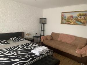 een woonkamer met een bank en een bed bij Garsoniera 1 decembrie in Alba Iulia