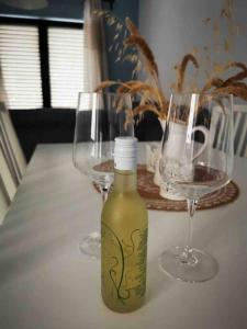two glasses and a bottle of wine on a table at Meraki Homestay Kanali in Kanali