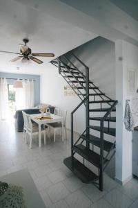 a black spiral staircase in a living room with a table at Meraki Homestay Kanali in Kanali +35 photos