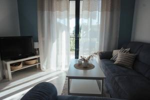 a living room with a couch and a tv and a table at Meraki Homestay Kanali in Kanali