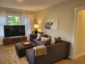 sala de estar con sofá y TV de pantalla plana en Modern Craftsman Garden Patio in Georgetown en Seattle