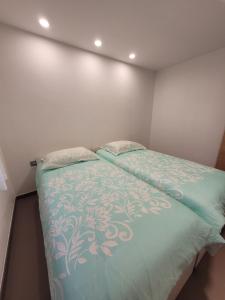 Apartment river Nadiža Podbela في Podbela: غرفة نوم مع سرير مع لحاف أخضر