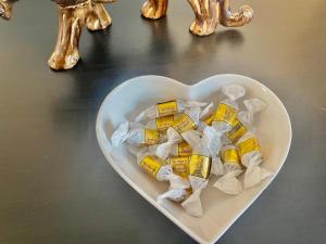 a white heart shaped bowl filled with yellow candy at Lovely self contained studio now available in London +5 photos