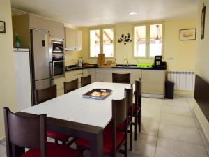 een keuken met een tafel en stoelen in een kamer bij Les Poujols 6 Pers in Viré