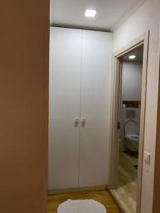 a bathroom with a white closet and a toilet at Cosy Home in Rustavi