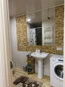 een badkamer met een wastafel en een wasmachine bij Cosy Home in Rustavi