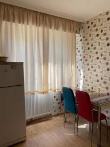 a kitchen with a table and chairs and a window at Cosy Home in Rustavi