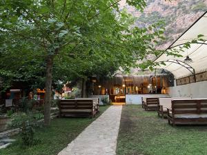 a patio with benches and a table and a building at KiDRAK OTEL MONTENEGRO-1 in Faralya