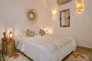 una camera con letto bianco e specchio di Riad Beata Bed & Breakfast a Marrakech