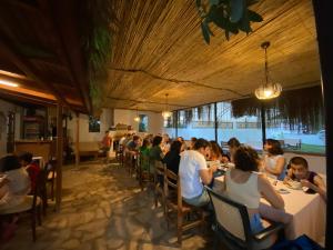 a group of people sitting at tables in a restaurant at KiDRAK OTEL MONTENEGRO-1 in Faralya