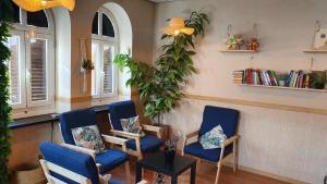a waiting room with blue chairs and a plant at GREEN Hostel MADRID GRAN VIA in Madrid