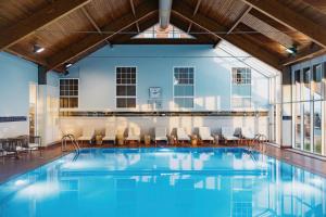 a pool with chairs and tables in a building at Marine Troon in Troon
