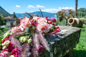 a bouquet of flowers sitting on a stone wall at il Motto di Tommy in Castelveccana
