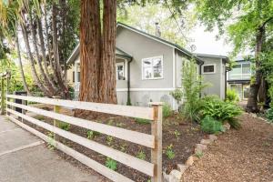 a house with a fence in front of a tree at Modern, new & industrial in Georgetown in Seattle