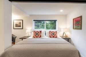 1 dormitorio con 1 cama grande con almohadas rojas en Modern, new & industrial in Georgetown en Seattle