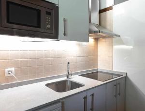 kuchnia ze zlewem i mikrofalówką w obiekcie El Manantial Del Fresno Casas Rurales En Hervás - Piscina - Desayunos - Barbacoa - Parking gratis w mieście Hervás