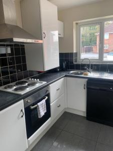 a kitchen with white cabinets and a stove top oven at The Glebe DN22 in Retford