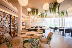 a dining room with tables and chairs and large windows at Hotel Primavera Park in Benidorm