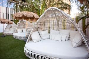 a white porch swing with white pillows and palm trees at Hotel Primavera Park in Benidorm