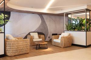 a lobby with wicker chairs and a table at Hotel Primavera Park in Benidorm