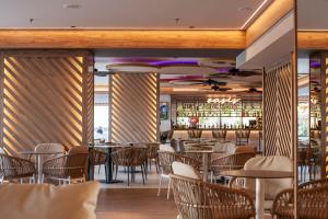 a restaurant with tables and chairs and a bar at Hotel Primavera Park in Benidorm