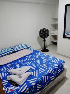 a bedroom with a bed with blue and white sheets at BARU ESTELAR in Medellín