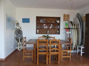 a dining room with a table and chairs and a surfboard at Warung in Lajares