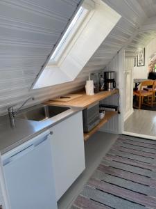 a small kitchen with a sink and a window at Fin lägenhet i hjärtat av Mölle in Mölle