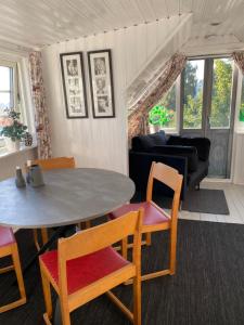 Fin lägenhet i hjärtat av Mölle في موليه: غرفة معيشة مع طاولة وكراسي