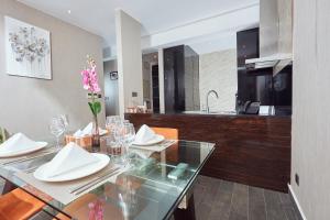 a dining room with a glass table and a kitchen at Bel Air Crest in Accra