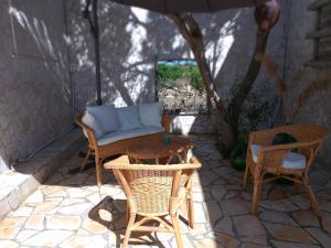 a patio with a table and chairs and an umbrella at Finestre Sul Mare Salento - Case Vacanze in Punta Prosciutto