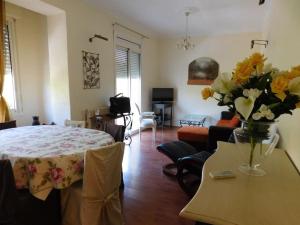 ein Wohnzimmer mit einem Tisch und einer Blumenvase in der Unterkunft Passerelle Opéra Perpignan in Perpignan